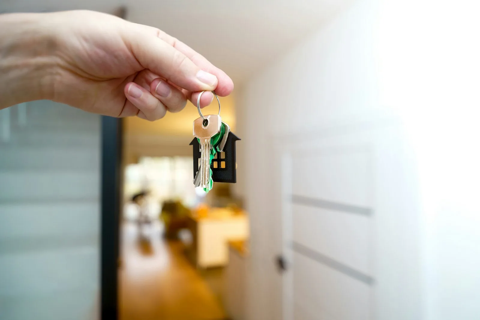 Main tenant le trousseau de clés d'un nouveau logement, porte-clés en forme de maison